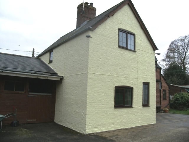 Front of brick house after exterior wall coatings