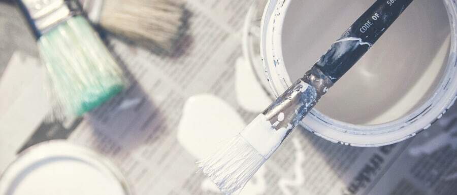 DIY paint tins and paint brushes on newspaper